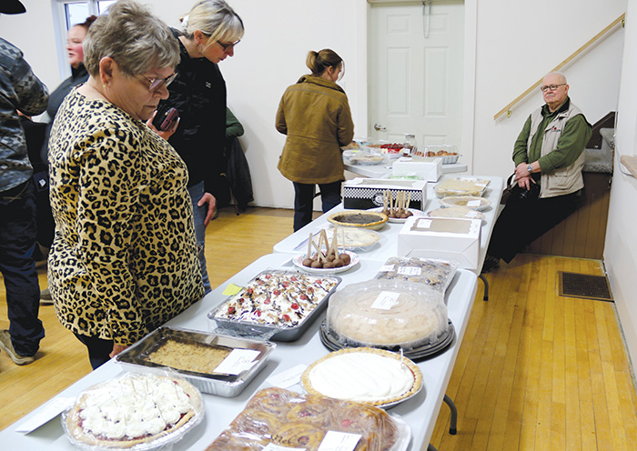 People looking over the selection of pies before bidding starts.<br />